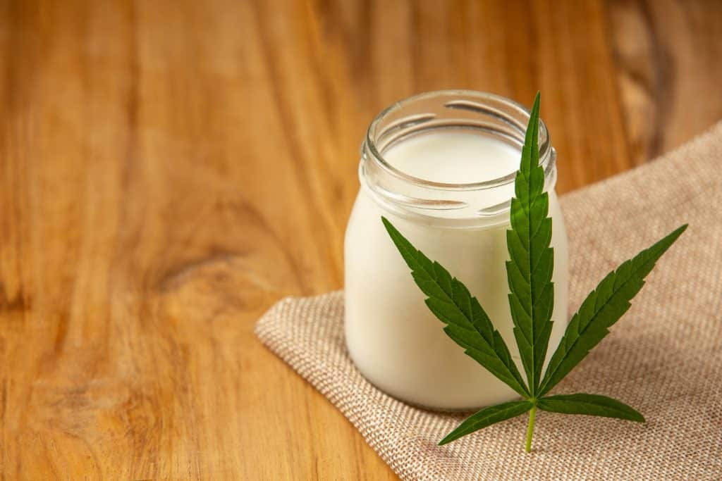 cannabis leaf beside a jar or milk