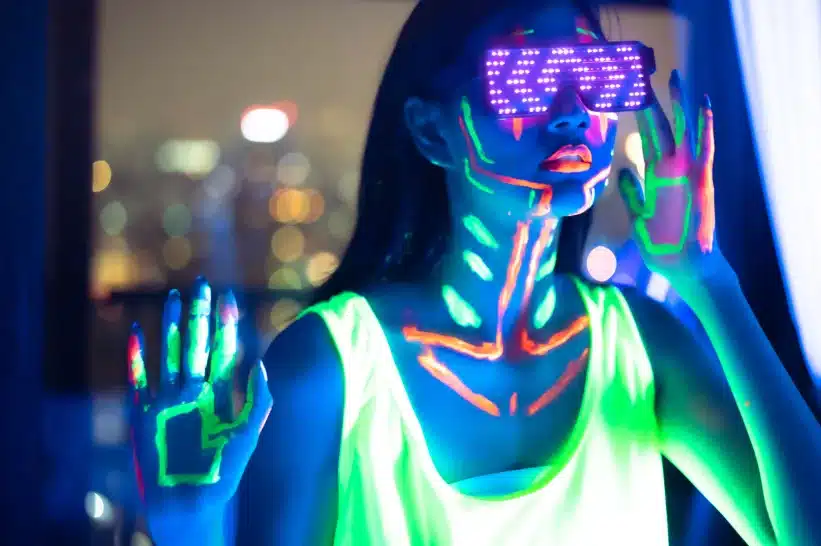 A model glowing with prints under a blacklight